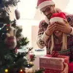 ajándék karácsony férfi befogja a fa mellett egy nő szemét