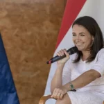 Novák Katalin köztársasági elnök mosolyog eu zászló magyar zászló előtt